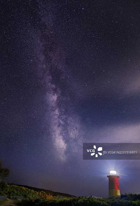 夜晚的米尔基威银河与美国伊斯瑟姆的灯塔相映成趣图片素材