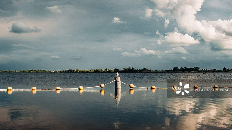 宁静的湖泊，水面倒映着戏剧性的天空，荷兰古达图片素材