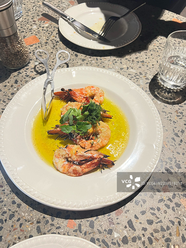 美味的虾菜肴，配有香草和酱汁，盛放在盘子里图片素材