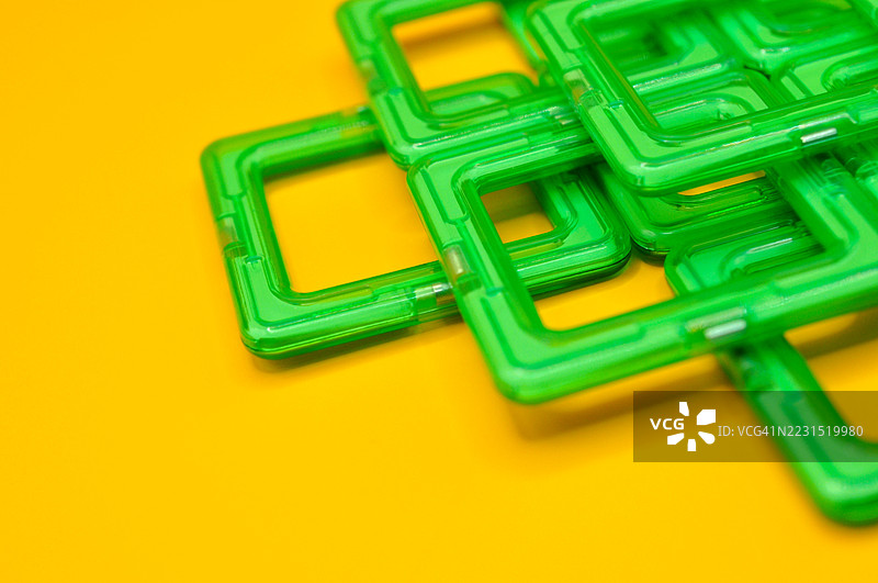 黄色背景上的绿色玩具积木图片素材