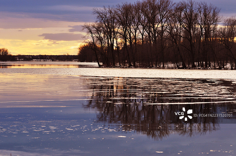 宁静的湖泊在日落时分映照着树木，加拿大图片素材