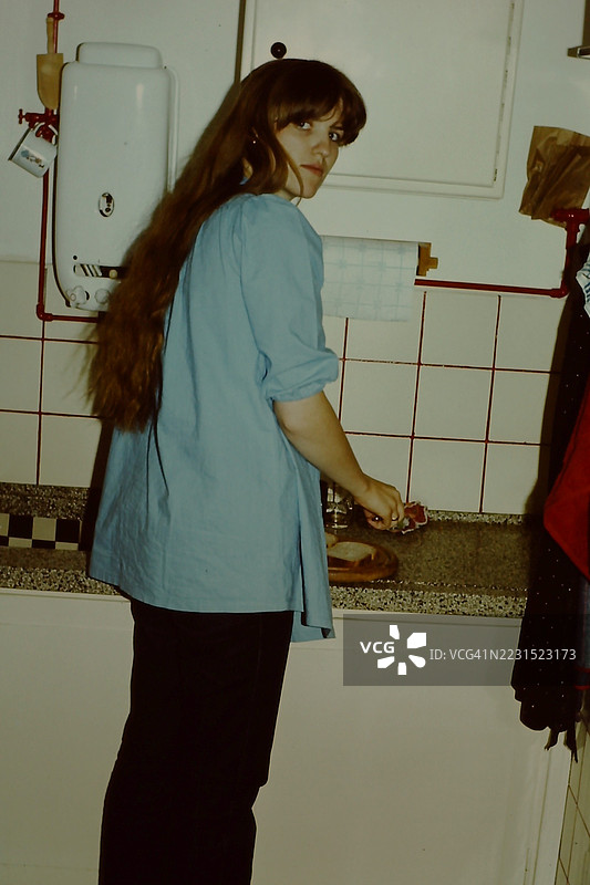 七十年代年轻女性在准备晚餐。图片素材