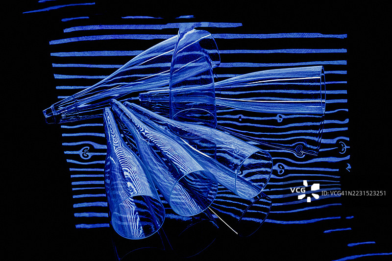 黑色背景上的蓝色发光玻璃锥体抽象光绘图片素材