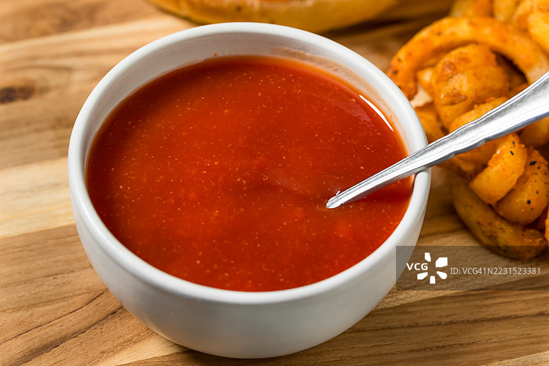 木桌上的番茄汤碗和卷曲薯条图片素材