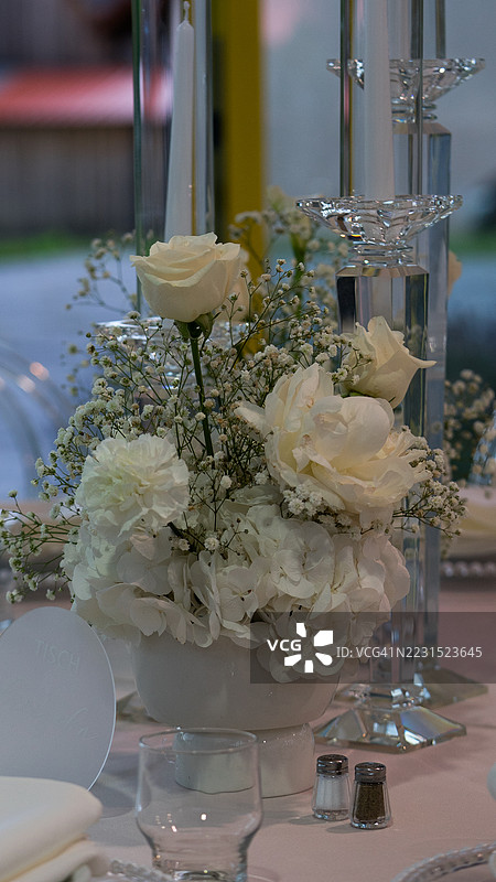 优雅的餐桌花卉布置与蜡烛图片素材