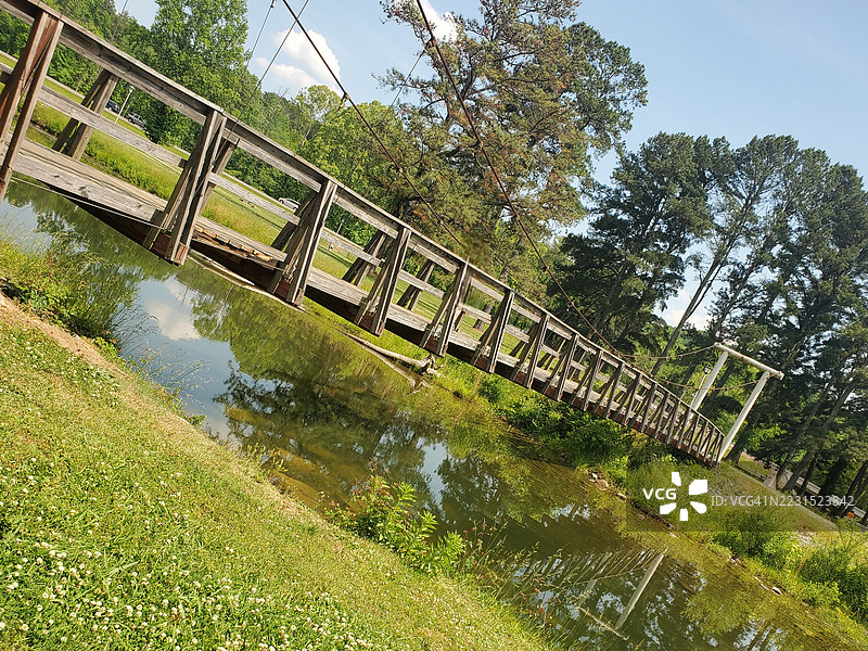 森林公园中的木桥横跨倒影池，位于美国代顿图片素材