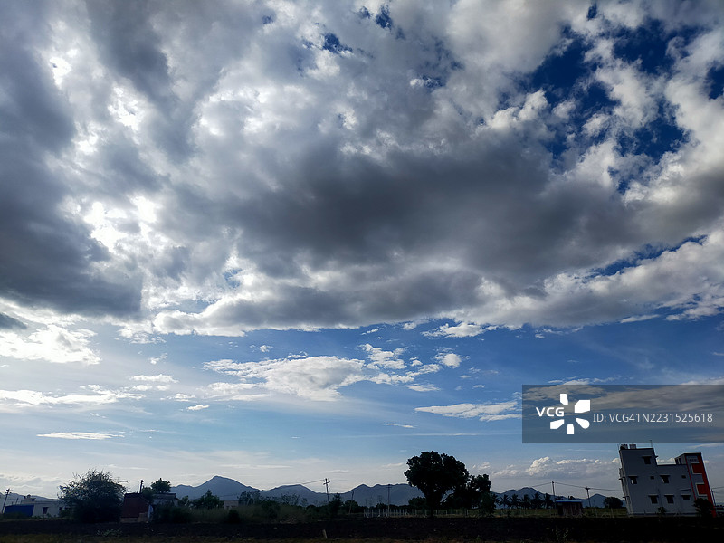戏剧性的天空与树木剪影和远处的山脉图片素材