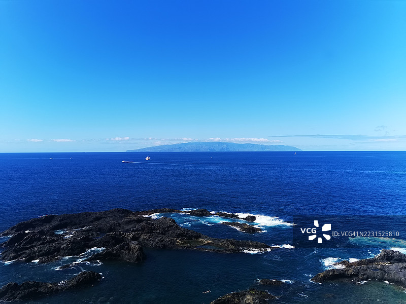 壮丽的海洋景观，岩石海岸线和远处的岛屿图片素材