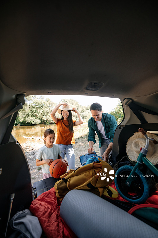 一家人带着孩子正在打包汽车后备箱准备野餐图片素材