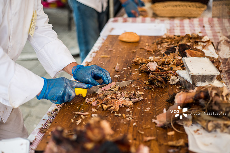 在意大利食品摊位的桌子上切割猪肉卷图片素材