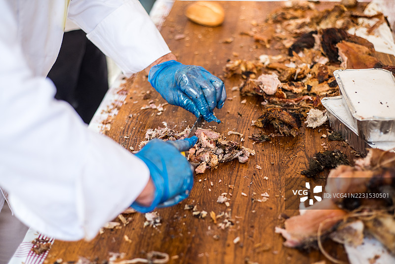 在意大利食品摊位的桌子上切割猪肉卷图片素材