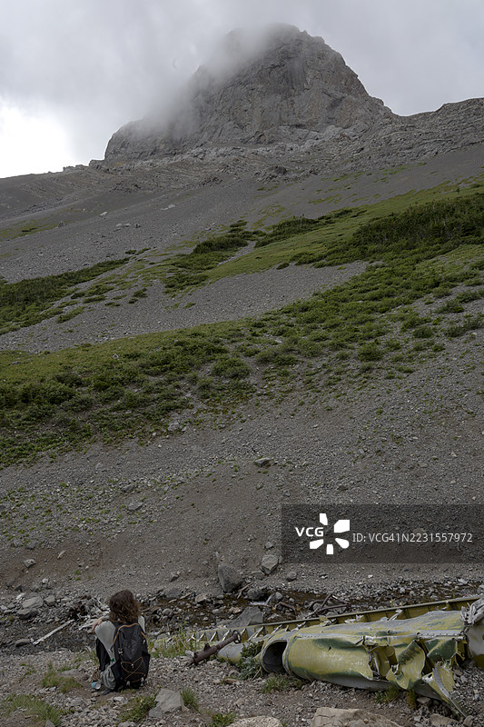 少年男孩在山上检查旧飞机残骸图片素材