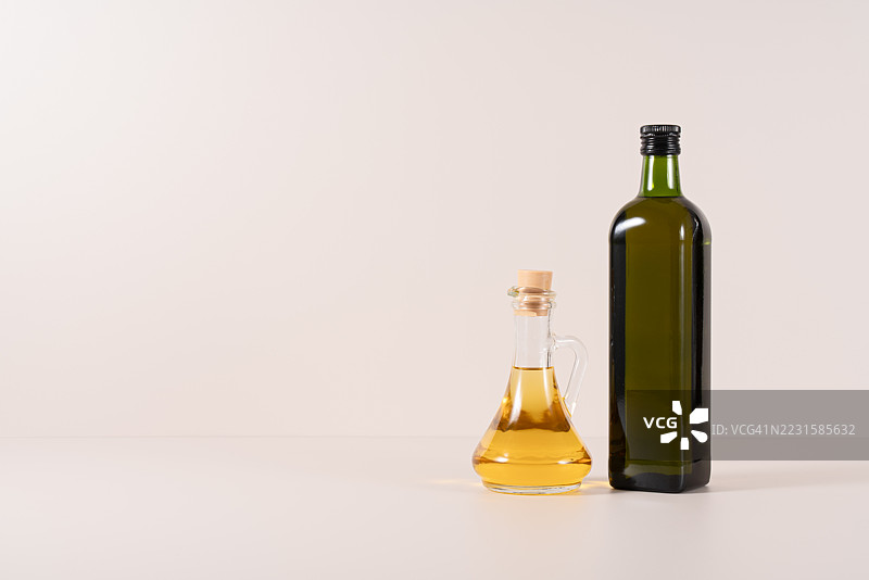 米色背景上的玻璃瓶装食用油图片素材