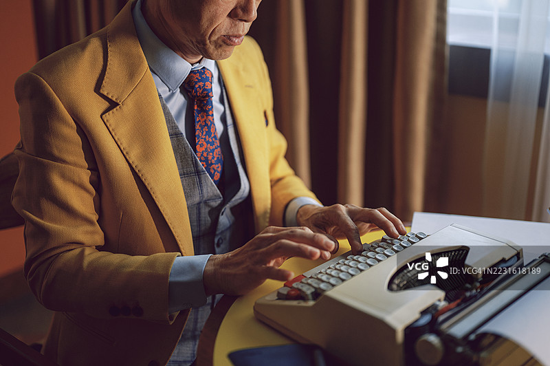 亚洲商人在复古打字机上打字图片素材