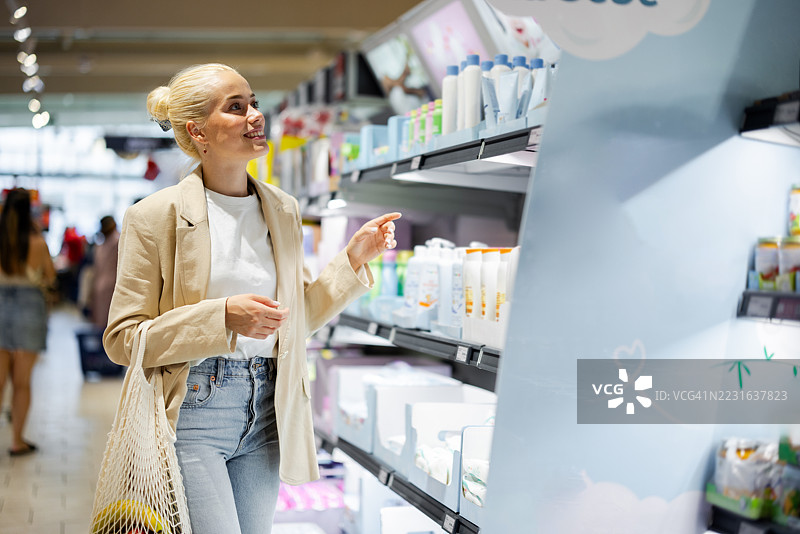年轻女性在超市挑选婴儿产品图片素材