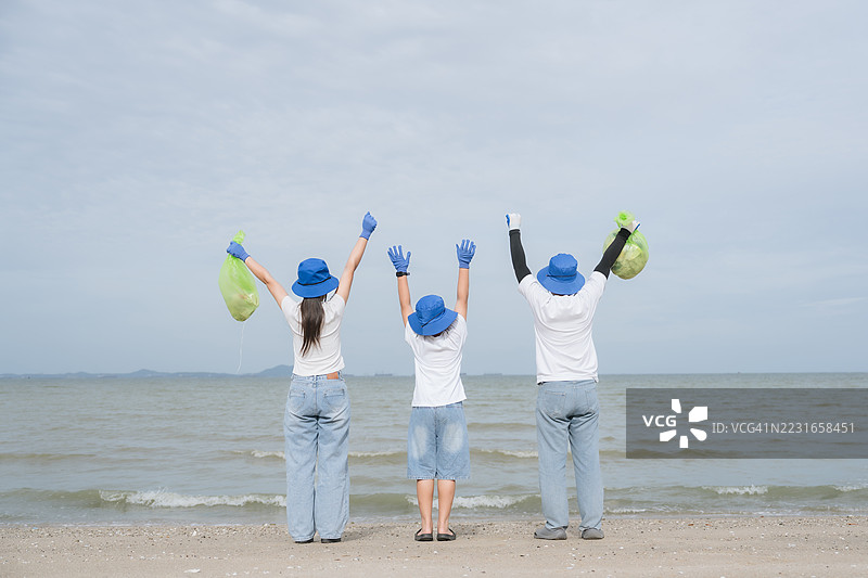 志愿者们在海滩清理活动后庆祝，快乐地收集沿海垃圾。图片素材
