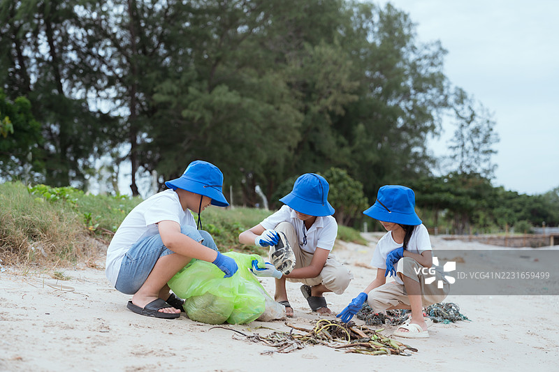 孩子们在阴天进行海滩清理活动，宣传环保意识图片素材