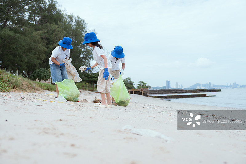 孩子们在阴天进行海滩清理活动，宣传环保意识图片素材
