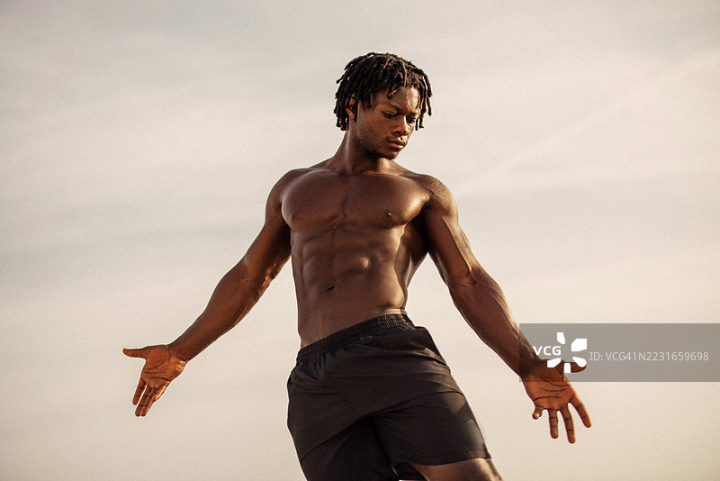 自信的运动男士在宁静阳光明媚的户外摆姿势图片素材