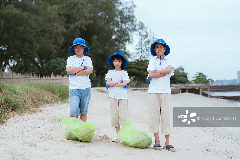 孩子们在阳光明媚的日子里参加海滩清理活动，宣传环保意识图片素材