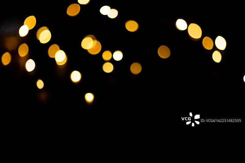 黑色背景上的金色散景灯光，留有空白空间。图片素材