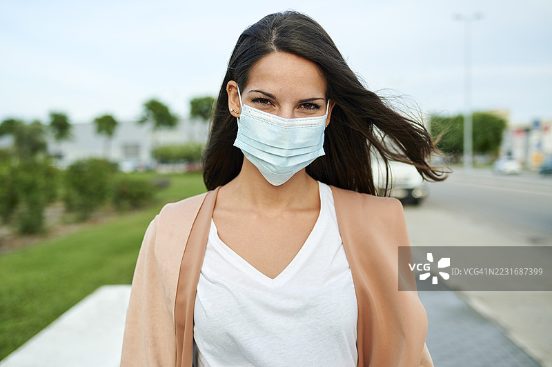 戴着防护口罩在城市里行走的女人图片素材