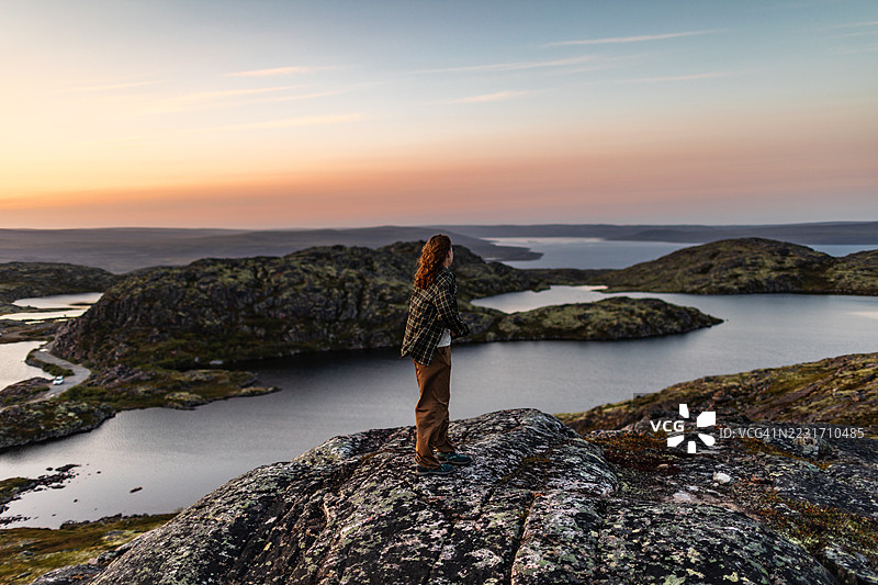 年轻女性在湖边享受日落图片素材