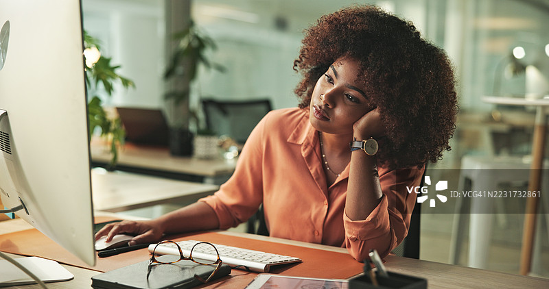深思熟虑的女商人在现代办公室的桌面上加班图片素材