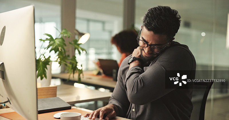 疲惫的职业男性在办公室工作站感到肌肉疼痛图片素材