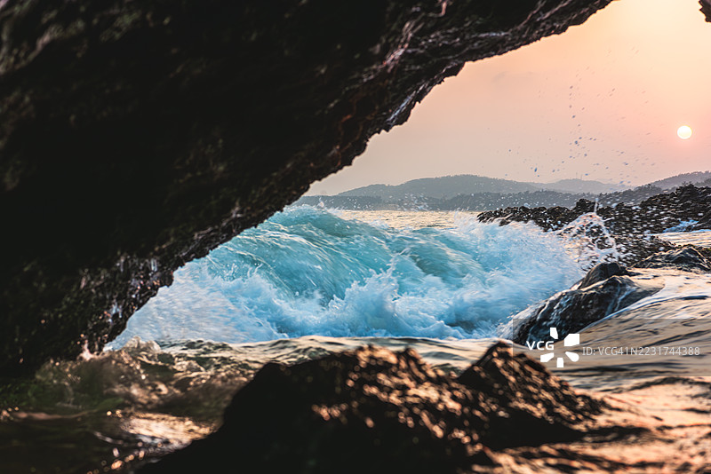 海边日落时海浪拍打岩石图片素材
