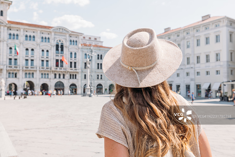 戴帽子的女性在历史悠久的欧洲广场游览图片素材