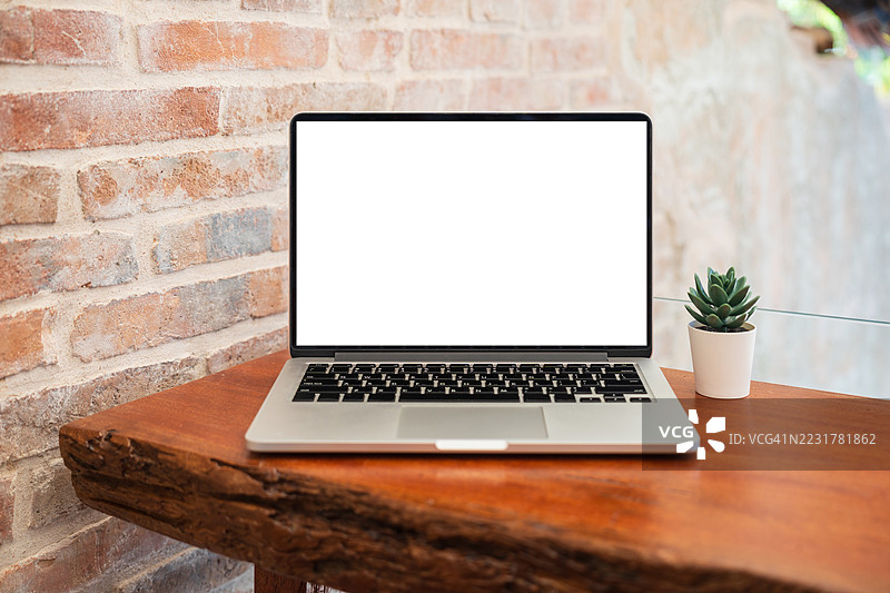 咖啡馆背景下桌子上的笔记本电脑空白屏幕。咖啡店桌子上的笔记本电脑空白屏幕，背景模糊。图片素材