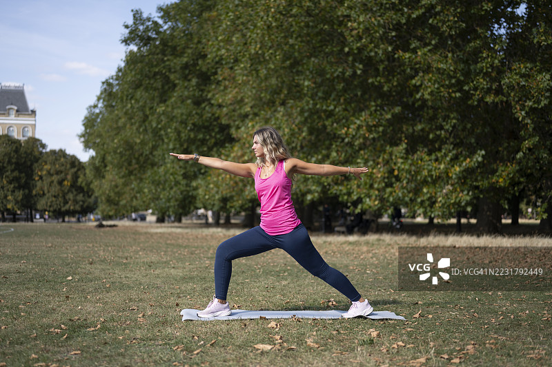 年轻女子在城市公园练习战士二式瑜伽图片素材
