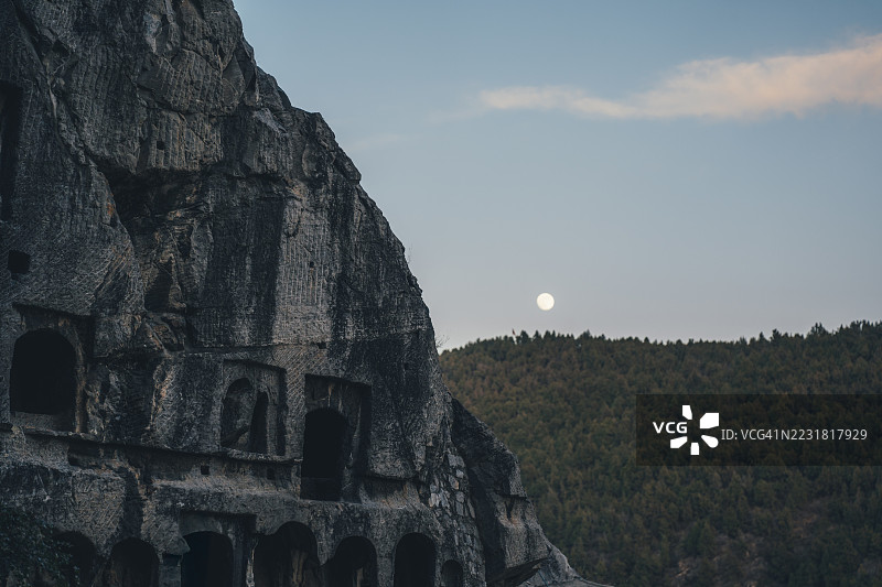 中国河南省洛阳龙门石窟的岩石雕刻与月升图片素材