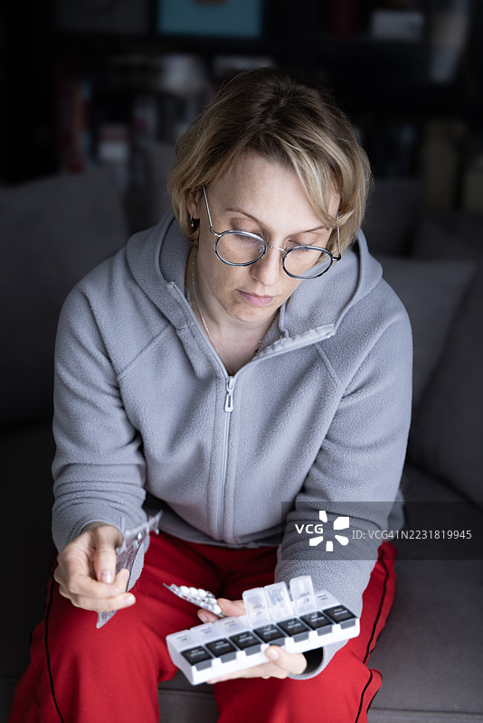 女性在家中整理每日药物药丸图片素材