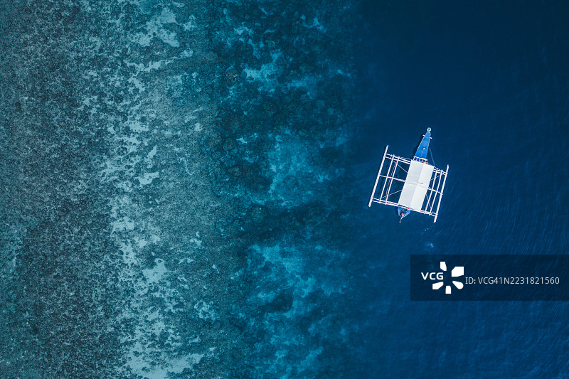 在菲律宾宿雾奥斯洛布附近的珊瑚礁上空俯瞰传统的班卡船图片素材