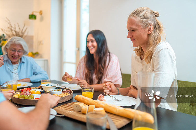 多地区家庭享用新鲜面包的欢乐早餐图片素材