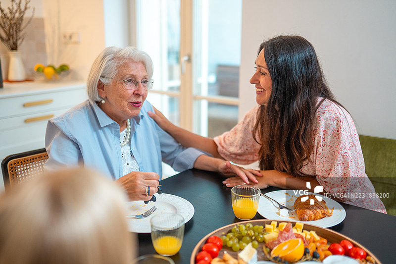 白种老人奶奶在家中与家人享用早餐图片素材