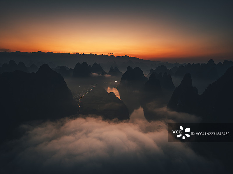 桂林，广西的喀斯特山峰上空的日出与晨雾图片素材