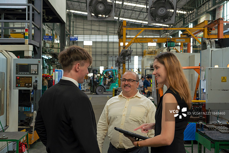 工厂车间商务会议，笑容满面的企业主与女性助理和保险公司代理人讨论业务策略。图片素材