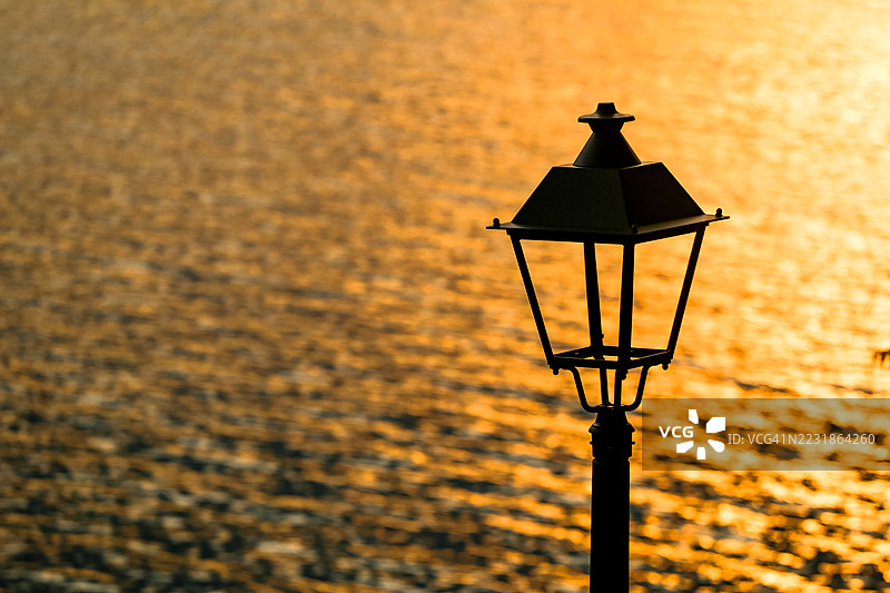 河边水面映衬下的路灯与日落图片素材