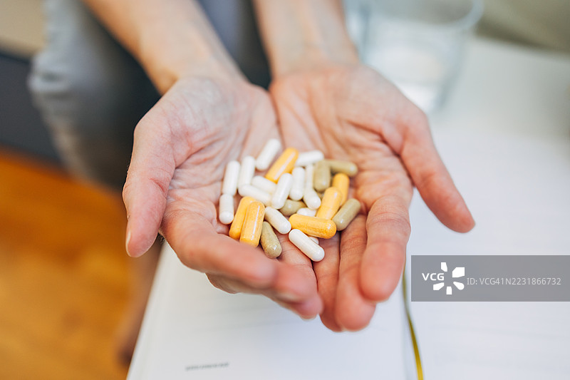 女人手中握着五颜六色的药丸图片素材