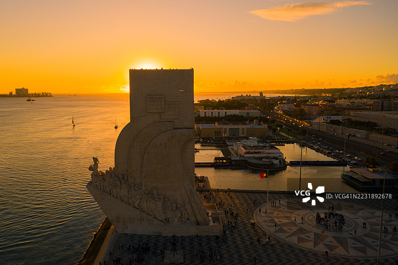 里斯本发现者纪念碑(Padrão dos Descobrimentos)和4月25日大桥的金色日落航拍景观图片素材