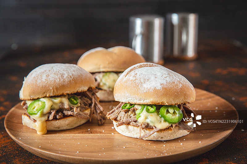 美味的牛肉拉丝三明治，配以墨西哥辣椒和融化的奶酪图片素材