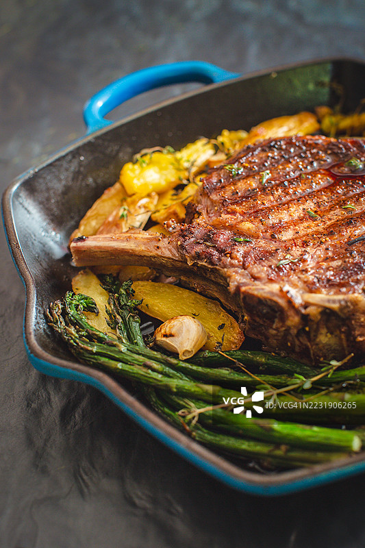 铸铁锅中烤制的牛排配蔬菜图片素材