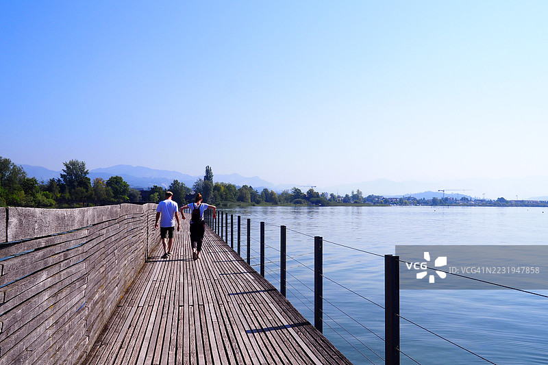 情侣走在通往拉珀斯维尔的步行桥上图片素材