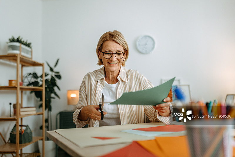 成熟的女性在家制作纸艺作品图片素材