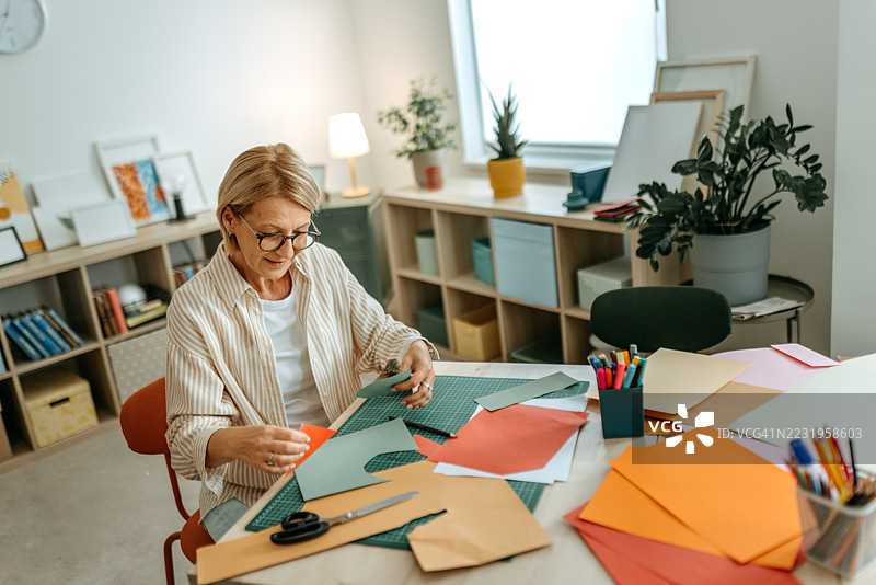老年女性在室内创作手工纸艺图片素材