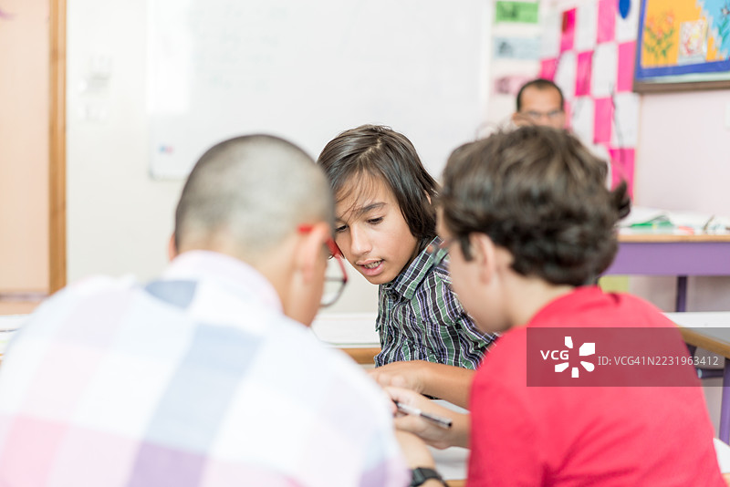 教室里的男孩在上课时交谈和低语图片素材