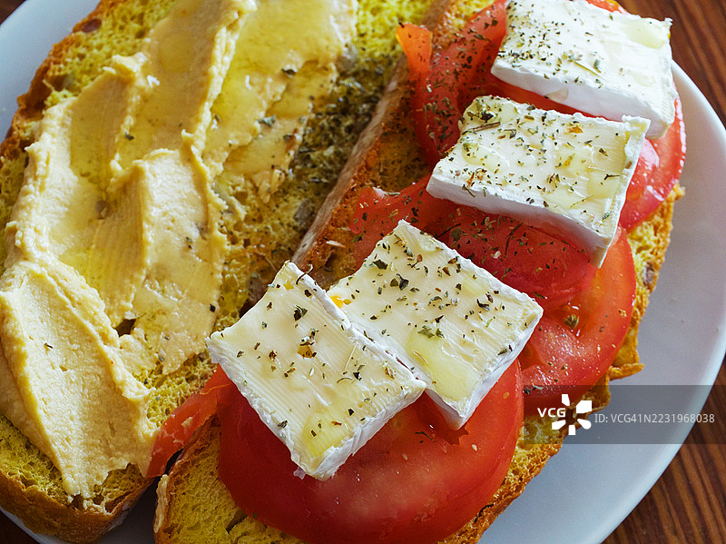 鹰嘴豆泥、番茄和卡蒙贝尔奶酪配面包图片素材